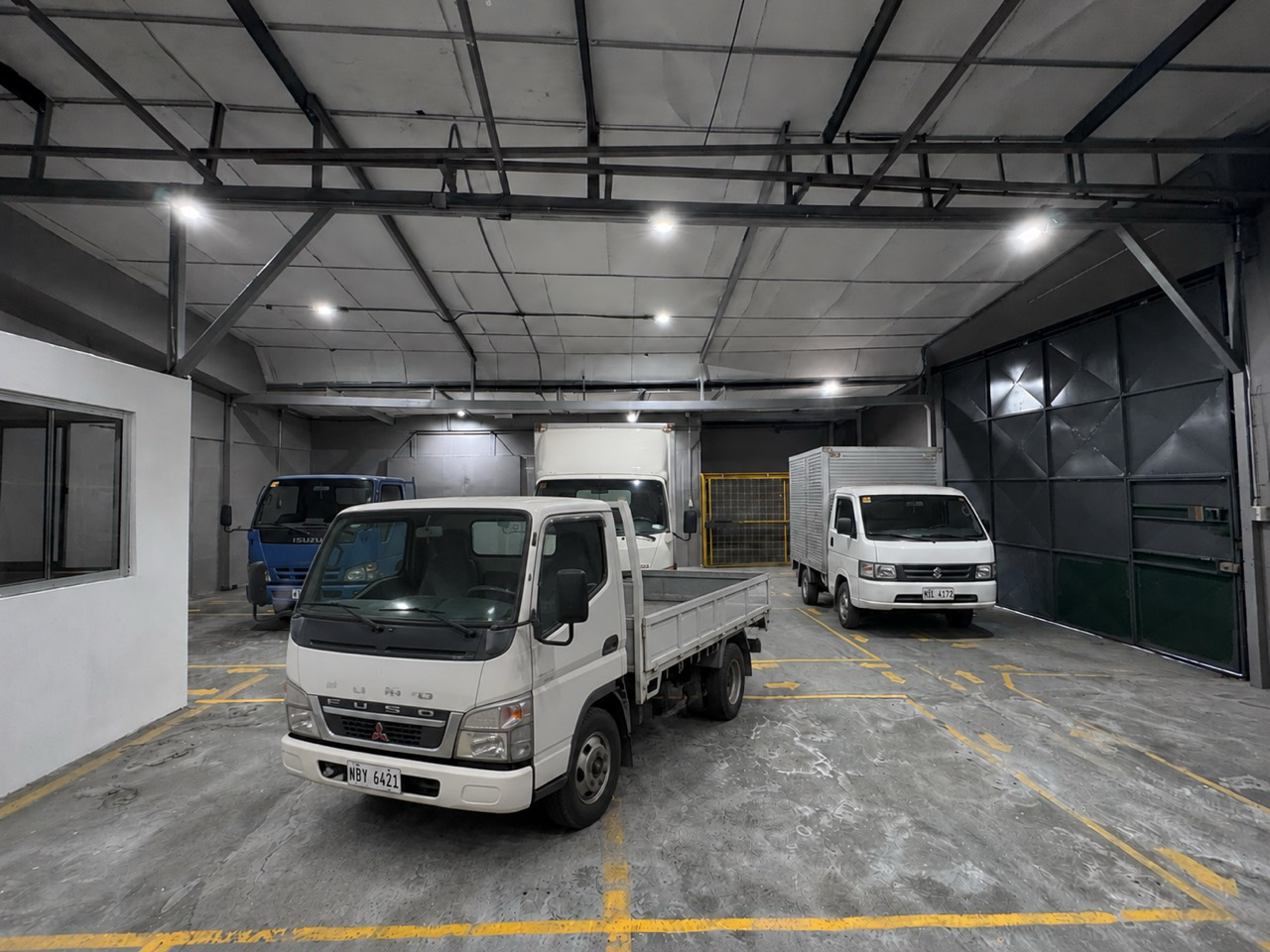 AI-generated visualization of commercial fleet trucks parked inside an illuminated warehouse